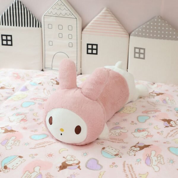 Soft My Melody pink plush toy lying on pastel themed kids' bed with cartoon prints.