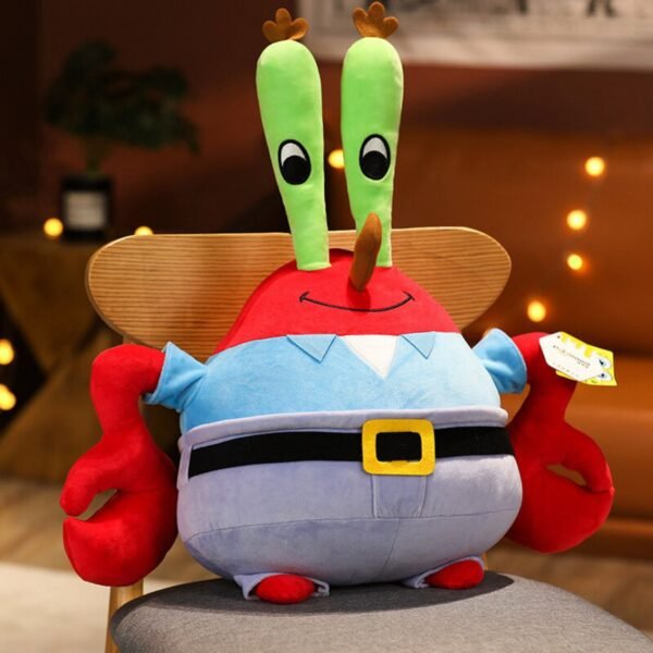 Mr. Krabs plush toy from SpongeBob SquarePants sitting on a chair, featuring his red body, green eye stalks, blue shirt and black belt with yellow buckle, with warm lighting in the background