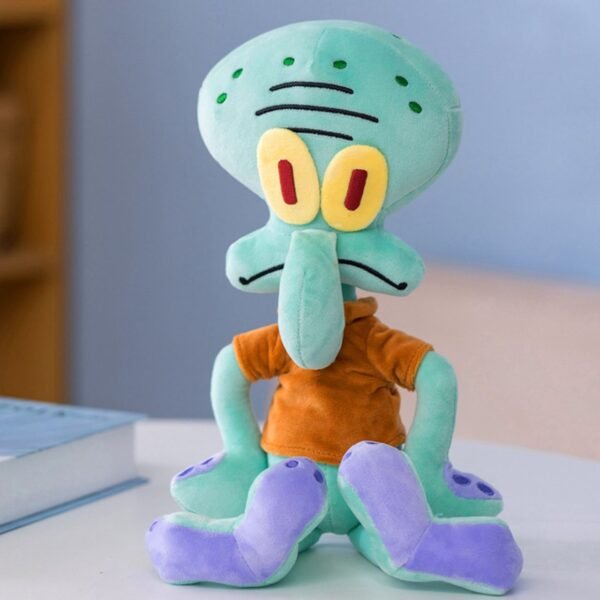 Squidward Tentacles plush toy from SpongeBob SquarePants, featuring his mint green body, yellow eyes with red pupils, orange shirt and purple-tipped tentacles, sitting upright on a white surface.